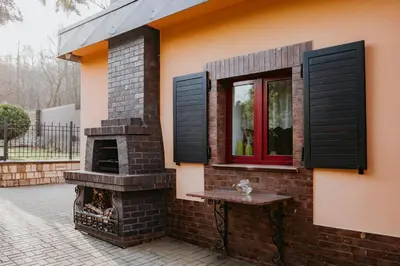 a brick house with a window and a fireplace at Apartamenty pod Dzwonkiem in Wadowice