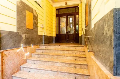 a yellow building with stairs leading to a door at Park Strzelecki Spacious Apartment by BookingHost in Kraków