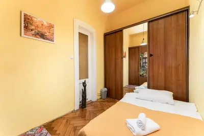 a bedroom with a bed with white towels on it at Park Strzelecki Spacious Apartment by BookingHost in Kraków