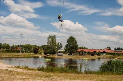 a person hanging from a rope over a river at Centrum Aktywnego Wypoczynku Borek in Rzezawa