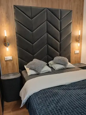 a bedroom with a large bed with a large padded headboard at Cracow Stay Inn Home in Kraków