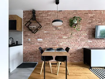 a kitchen with a brick wall and a table and chairs at Halicka Apartment Free Parking by CityBeat in Kraków