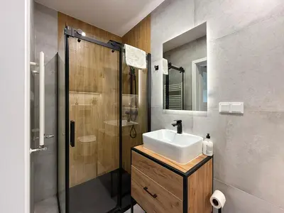 a bathroom with a sink and a shower at Halicka Apartment Free Parking by CityBeat in Kraków