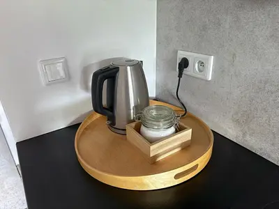 a coffee maker on a wooden table with a phone at Halicka Apartment Free Parking by CityBeat in Kraków