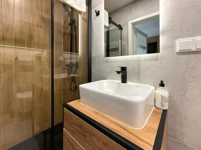 a bathroom with a white sink and a shower at Halicka Apartment Free Parking by CityBeat in Kraków