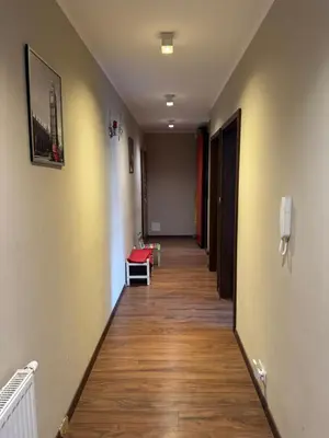 a long hallway with a red chair in a room at Supreme Luxury Apartment in Kraków