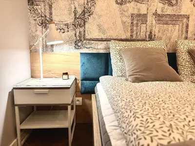 a bedroom with a bed and a nightstand with a lamp at The Vinci Residence, Kraków Old Town in Kraków