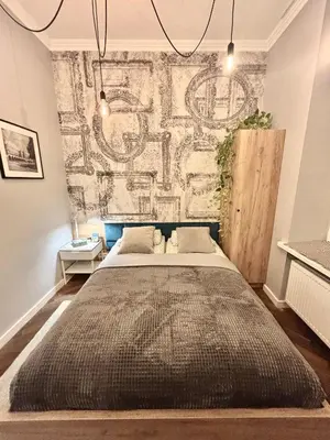 a bedroom with a large bed in front of a wall at The Vinci Residence, Kraków Old Town in Kraków