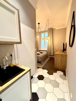 a kitchen with a black and white tiled floor at The Vinci Residence, Kraków Old Town in Kraków