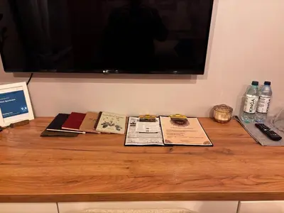 a wooden table with a television and books on it at The Vinci Residence, Kraków Old Town in Kraków
