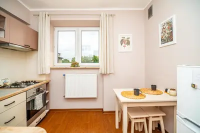 a kitchen with a table and a small table with chairs at Apartament Clover by Meadow Stay Apartments in Kraków