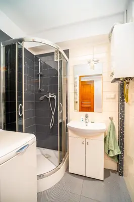 a bathroom with a shower and a sink and a tub at Apartament Clover by Meadow Stay Apartments in Kraków
