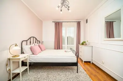 a bedroom with a bed with pink pillows and a window at Apartament Clover by Meadow Stay Apartments in Kraków