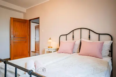 a bedroom with a large bed with pink pillows at Apartament Clover by Meadow Stay Apartments in Kraków
