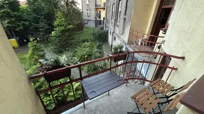 a balcony with two chairs and a bench at Sunny Apartment near Krakus Mound in Kraków