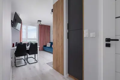 a kitchen and dining room with a table and chairs at Przestronny Apartament z Balkonem by Noclegi Renters in Kraków