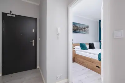 a bedroom with a bed and a large mirror at Przestronny Apartament z Balkonem by Noclegi Renters in Kraków