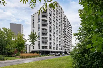a tall white building on the side of a street at Przestronny Apartament z Balkonem by Noclegi Renters in Kraków