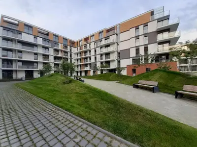 a grassy area with a couch in front of a building at Rakowicka Apartment - free parking in Kraków