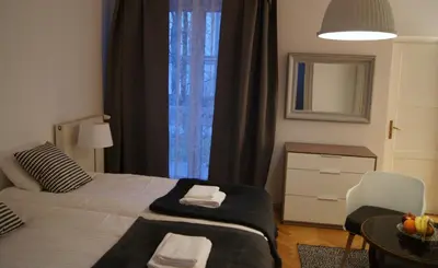 a bedroom with a bed and a table and a mirror at Apartament Daszyńskiego in Kraków