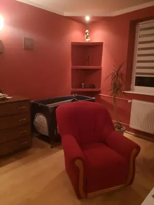 a red living room with a red chair and a tub at Bramka do lasu in Dąbrowa Górnicza
