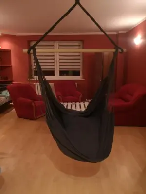 a black hammock in a living room with two red chairs at Bramka do lasu in Dąbrowa Górnicza