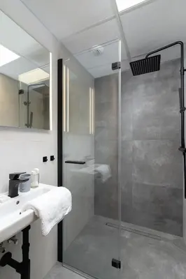 a bathroom with a glass shower and a sink at Modern Studios with Air Conditioning in Downtown Kraków by Noclegi Renters in Kraków