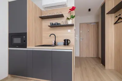 a kitchen with a sink and a microwave at Modern Studios with Air Conditioning in Downtown Kraków by Noclegi Renters in Kraków