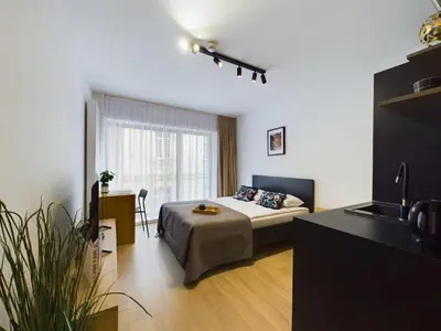 a bedroom with a bed and a desk and a television at Modern Studios with Air Conditioning in Downtown Kraków by Noclegi Renters in Kraków