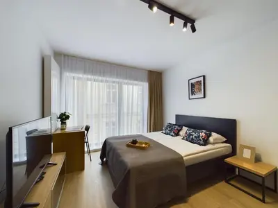 a bedroom with a bed and a television in it at Modern Studios with Air Conditioning in Downtown Kraków by Noclegi Renters in Kraków
