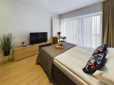 a bedroom with a large bed and a flat screen tv at Modern Studios with Air Conditioning in Downtown Kraków by Noclegi Renters in Kraków