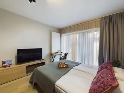 a hotel room with a bed and a flat screen tv at Modern Studios with Air Conditioning in Downtown Kraków by Noclegi Renters in Kraków