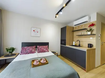 a bedroom with a bed and a kitchen at Modern Studios with Air Conditioning in Downtown Kraków by Noclegi Renters in Kraków