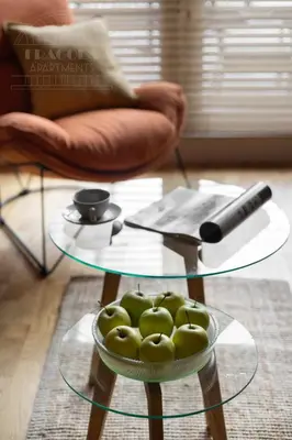 a glass table with a bowl of green apples on it at Cityscape Fragola Apartments in Kraków