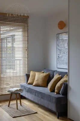 a blue couch in a living room with a window at Cityscape Fragola Apartments in Kraków