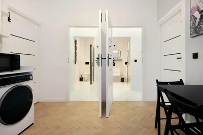 a white room with a bedroom and a bed at Roomy apartments Łobzowska Street in Kraków