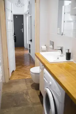 a bathroom with a sink and a washing machine at Old Town Parkview Apartment in Kraków