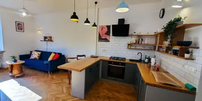 a kitchen and living room with a blue couch at Old Town Parkview Apartment in Kraków