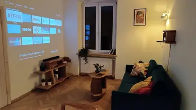 a living room with a couch and a large screen at Old Town Parkview Apartment in Kraków