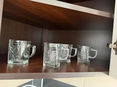 three empty glass mugs sitting on a shelf at Maldives for three in Jaworzno