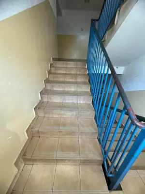 a staircase with blue rail and tile floor at Maldives for three in Jaworzno