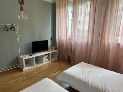 a living room with a television on a white table at Maldives for three in Jaworzno