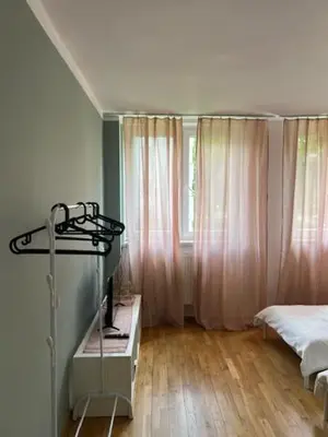 a bedroom with a bed and a dresser in front of a window at Maldives for three in Jaworzno