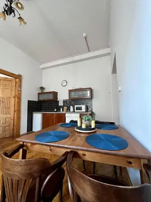 a kitchen with a wooden table with blue mats on it at Old Town Apartments in Kraków
