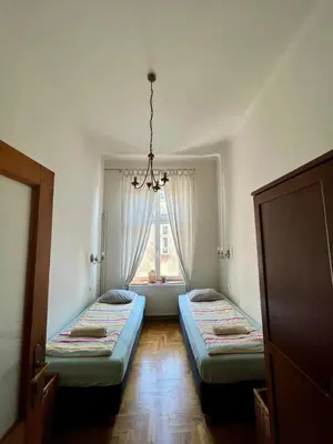 two beds in a room with a window at Old Town Apartments in Kraków