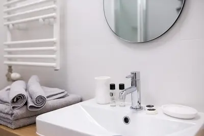 a white bathroom with a sink and a mirror at Kazimierz - Starowiślna 41 street in Kraków