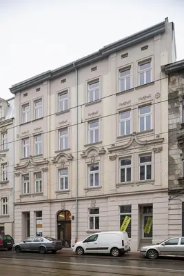 a large building with cars parked in front of it at Kazimierz - Starowiślna 41 street in Kraków