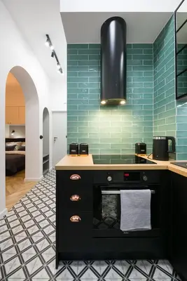 a kitchen with a black counter and green tiles at Kazimierz - Starowiślna 41 street in Kraków