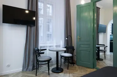 a room with a table and chairs and a green door at Kazimierz - Starowiślna 41 street in Kraków