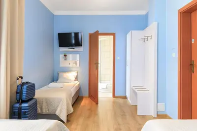 a room with two beds and a television on a wall at Freedom Hostel in Kraków